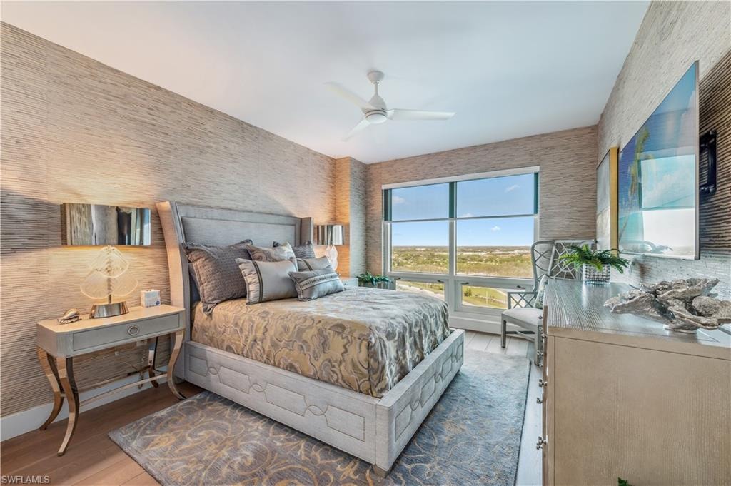 Bedroom featuring wallpapered walls, and wood finished floors