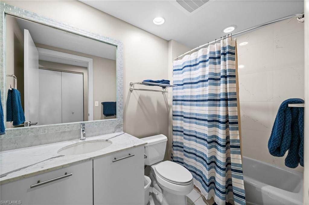 Bathroom with vanity, shower / bath combination with curtain, recessed lighting, and light tile patterned floors