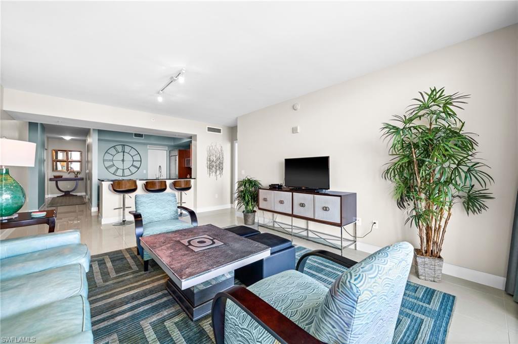 Living area with a water view, expansive windows, and tile patterned floors