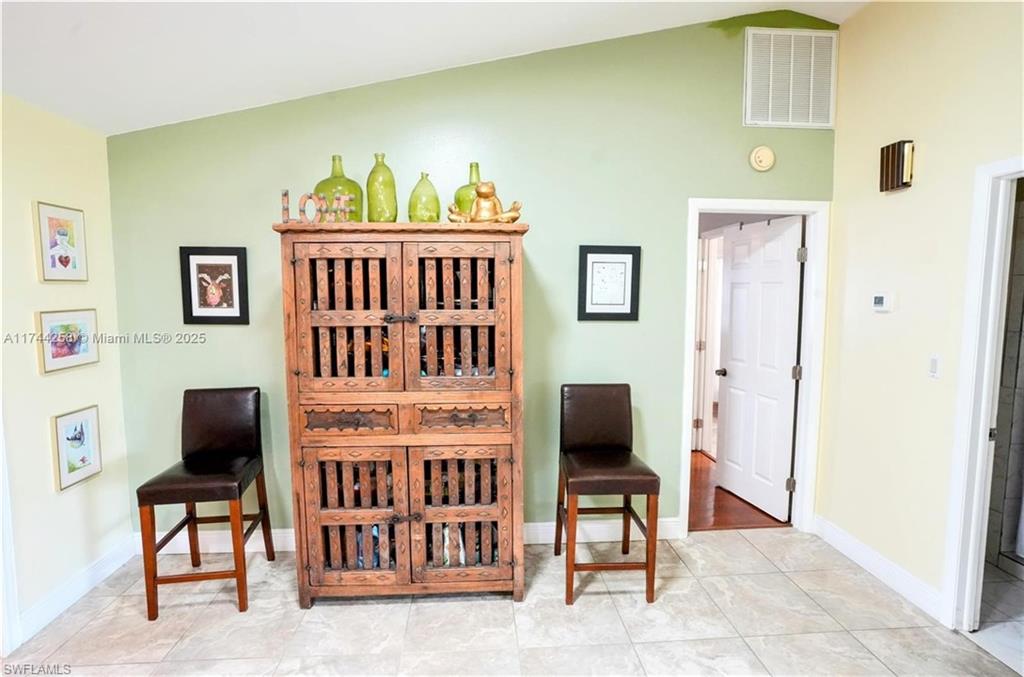 Dining area with light tile patterned floors and lofted ceiling