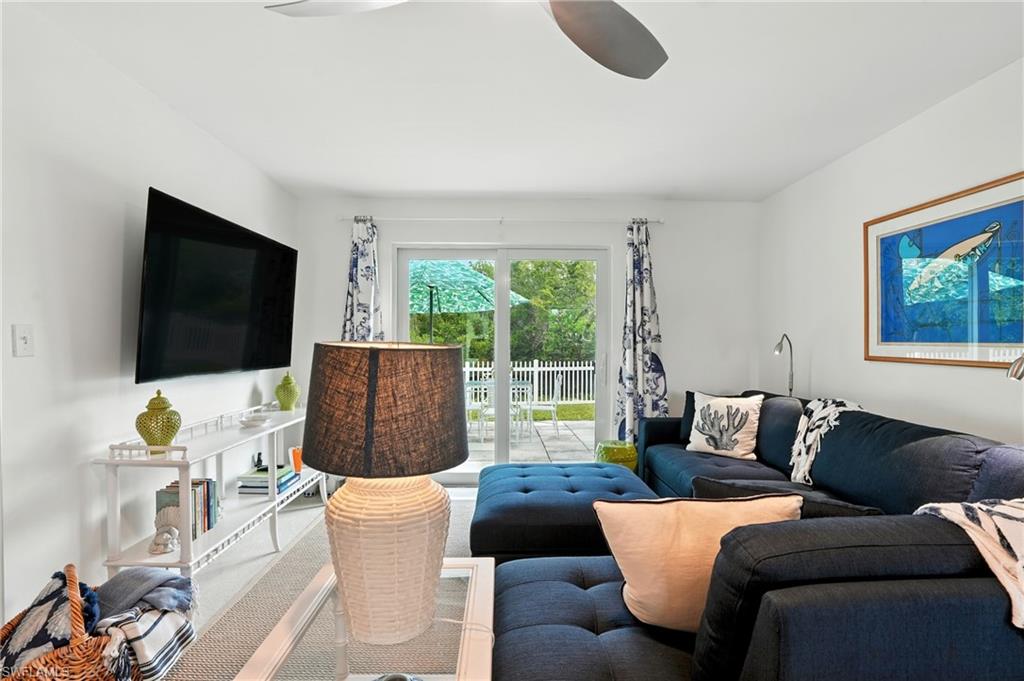 Carpeted living area with a ceiling fan