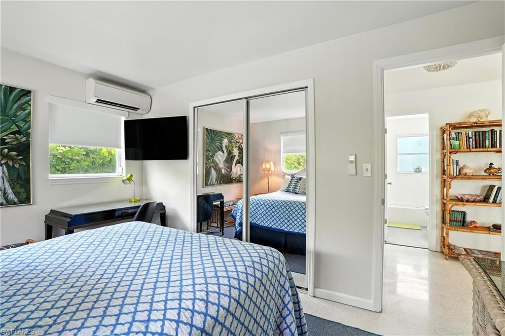 Bedroom with a closet, a wall unit AC, and speckled floor