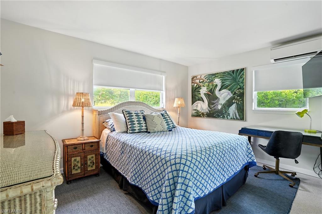 Bedroom featuring a wall mounted AC and carpet flooring