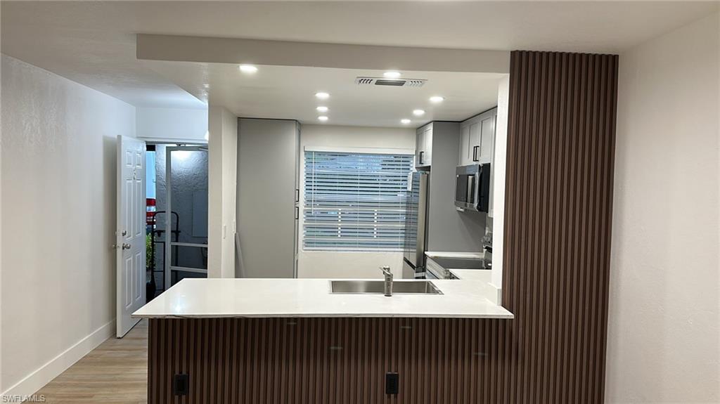 Bathroom with recessed lighting, vanity, and light wood-style flooring