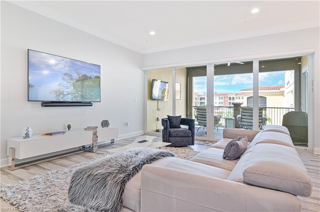 Living area featuring wood finished floors, crown molding, and recessed lighting