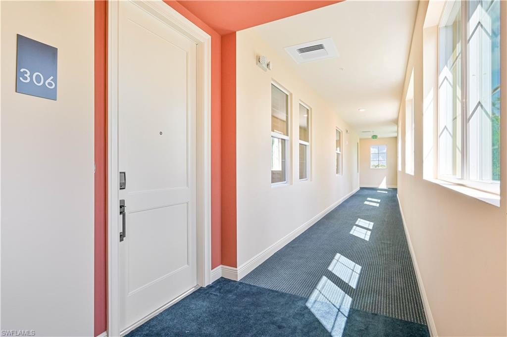 Corridor featuring carpet flooring and baseboards