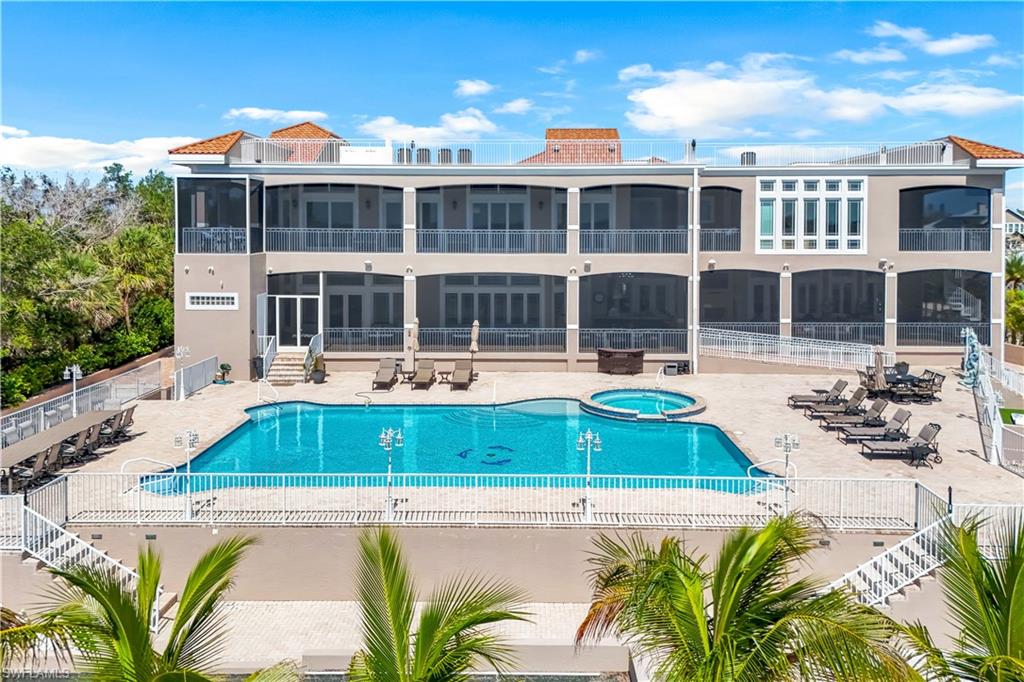 View of pool with a patio and a pool with connected hot tub