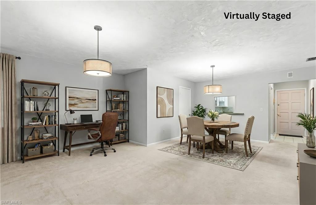 Dining room featuring light colored carpet, a desk, and a textured ceiling