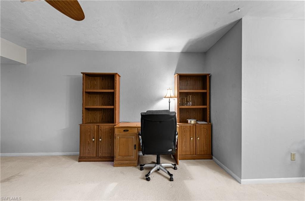 Office space with light carpet, a textured ceiling, and a ceiling fan