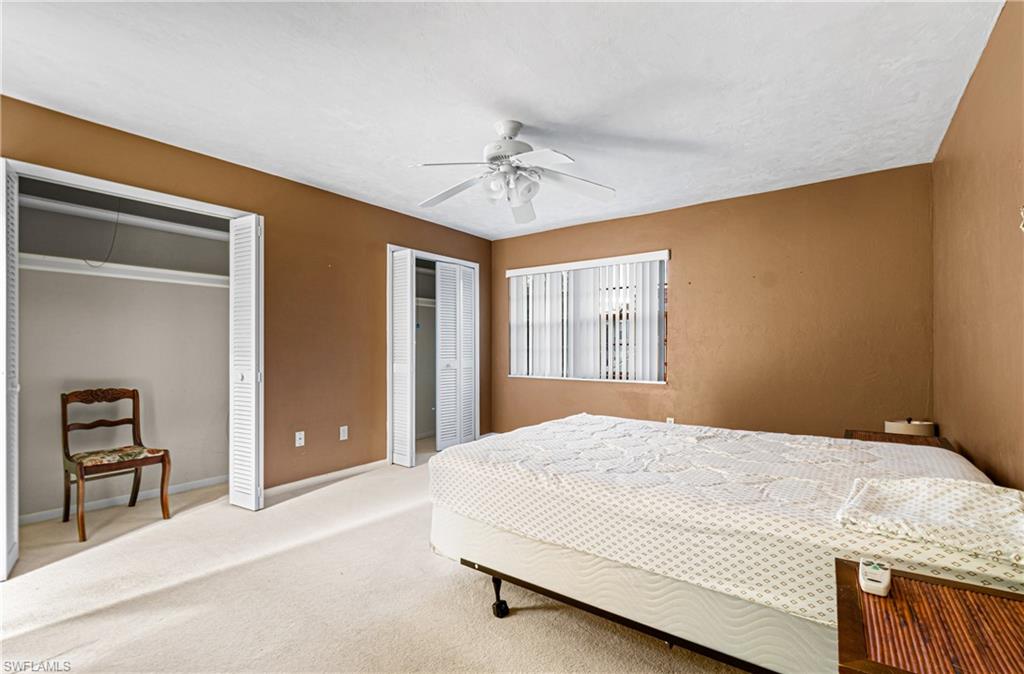 Bedroom with multiple closets, carpet flooring, and a ceiling fan