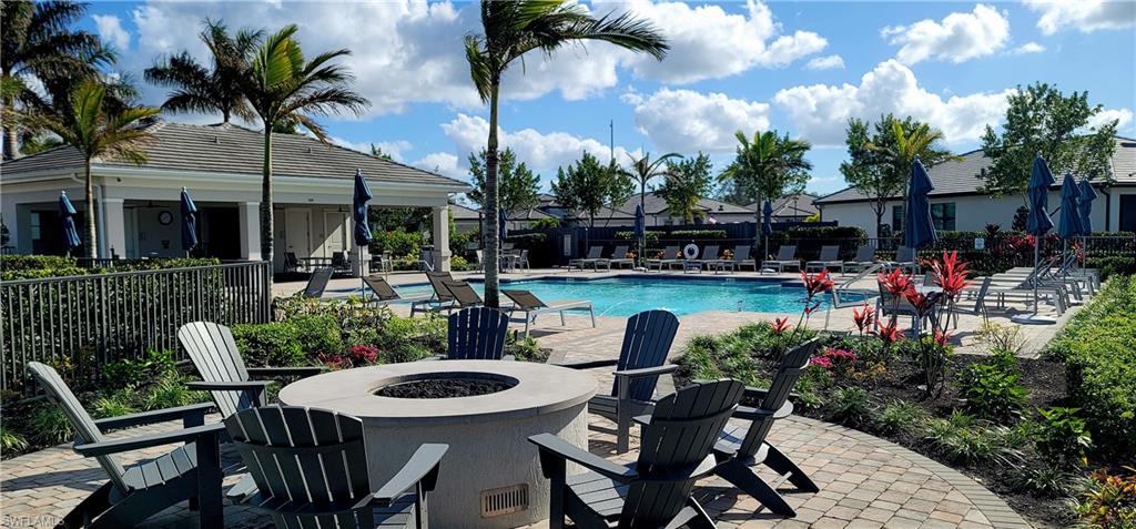 View of community pool with a patio area and an outdoor fire pit