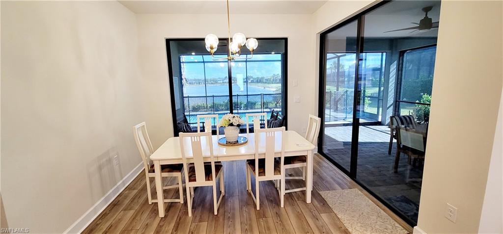 Dining area with wood-type flooring and ceiling fan with notable chandelier