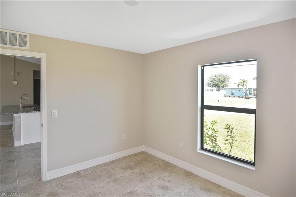 Spare room featuring baseboards and light tile patterned floors