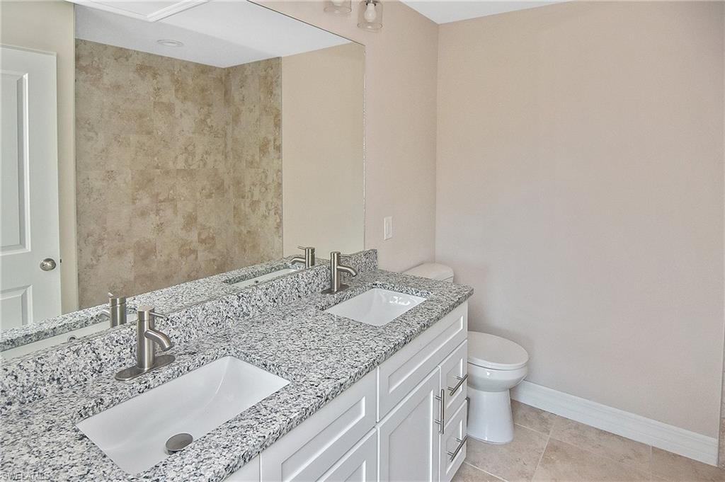 Bathroom featuring double vanity and light tile patterned floors