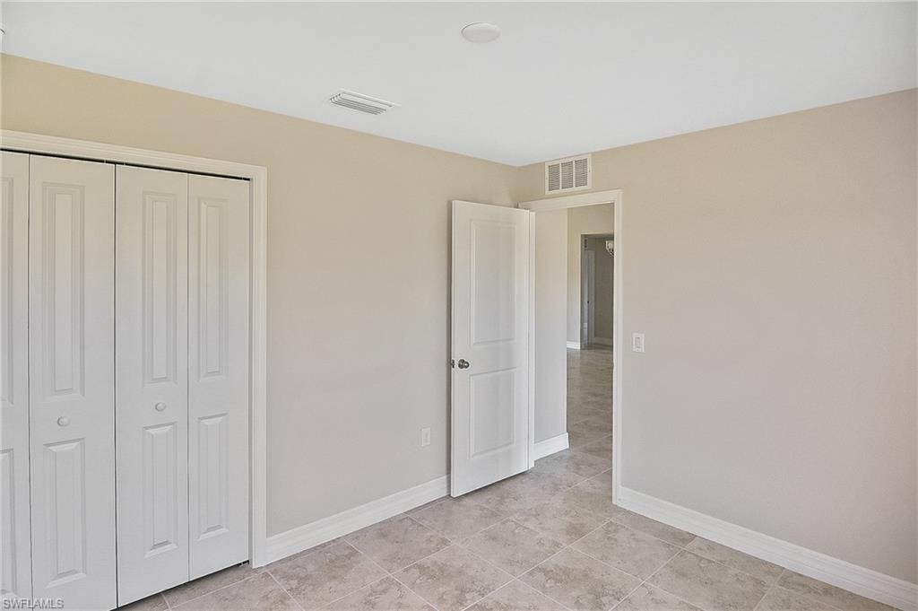 Unfurnished bedroom featuring a closet and light tile patterned floors