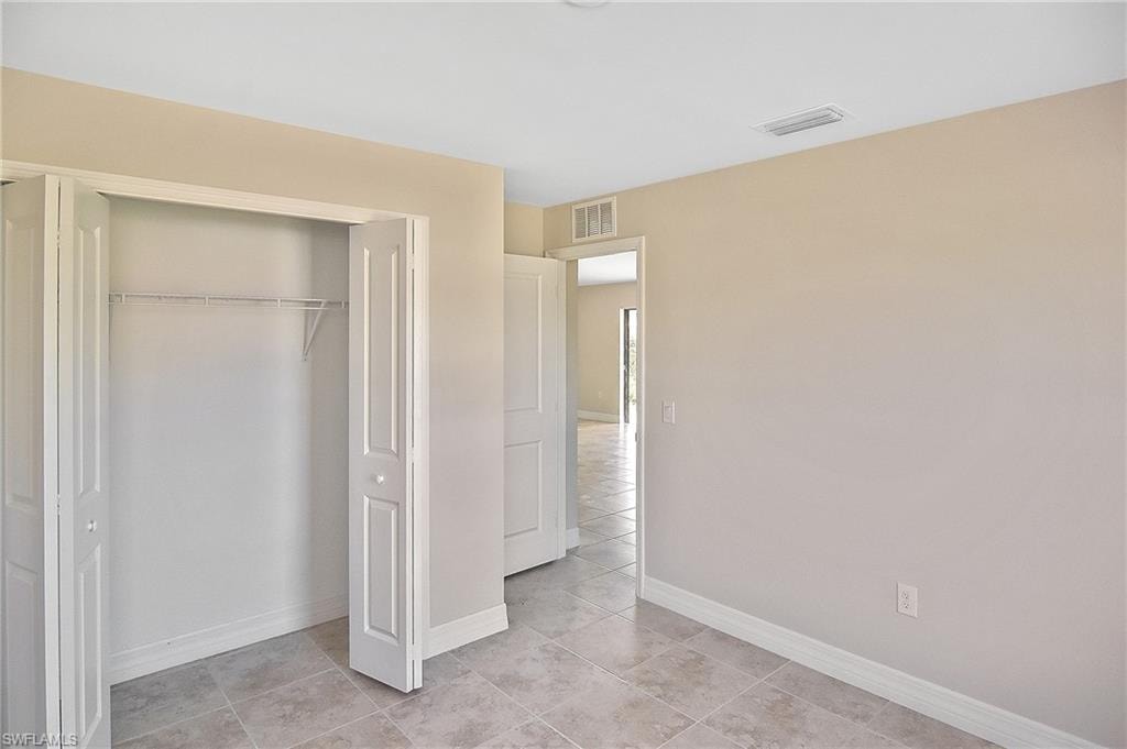 Unfurnished bedroom with light tile patterned floors and a closet