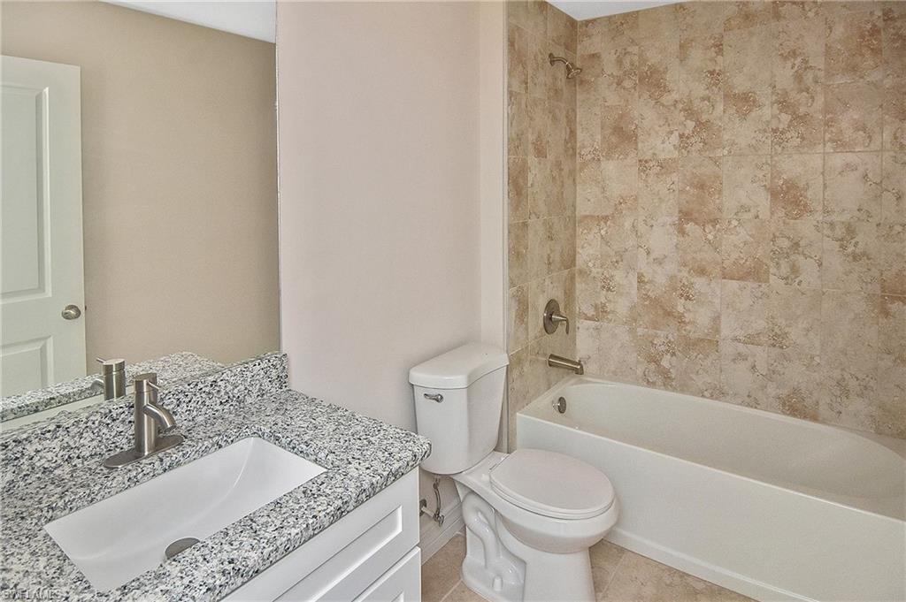 Full bath featuring bathtub / shower combination, vanity, and light tile patterned floors