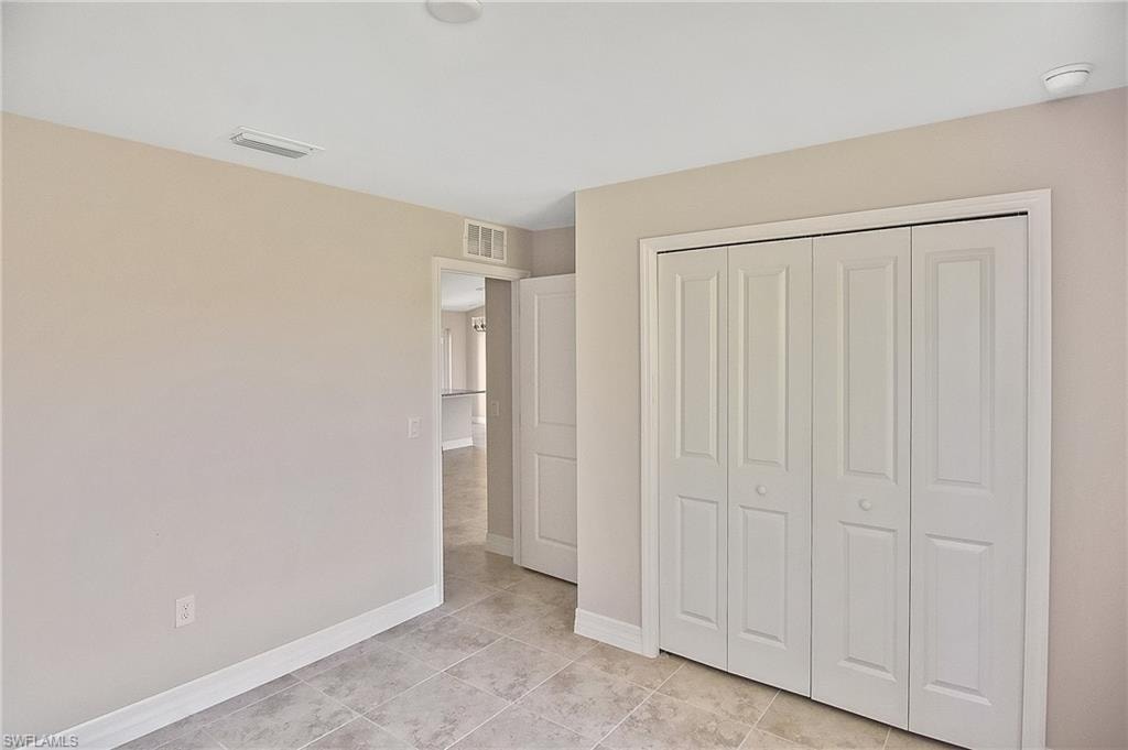 Unfurnished bedroom featuring a closet and light tile patterned flooring