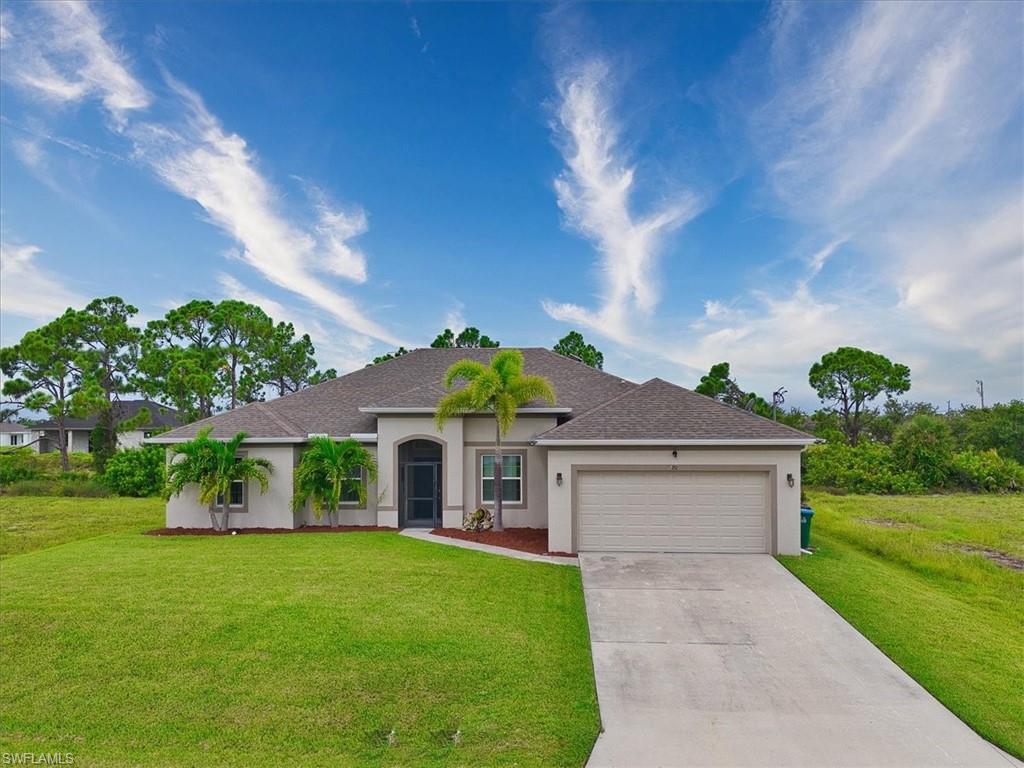 Ranch-style house featuring a front lawn, driveway, roof with shingles, and an attached garage