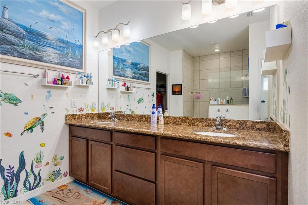Mast. Bathroom with double vanity and tiled shower