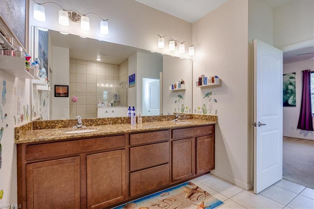 Mast. Bathroom featuring light tile patterned floors, double vanity