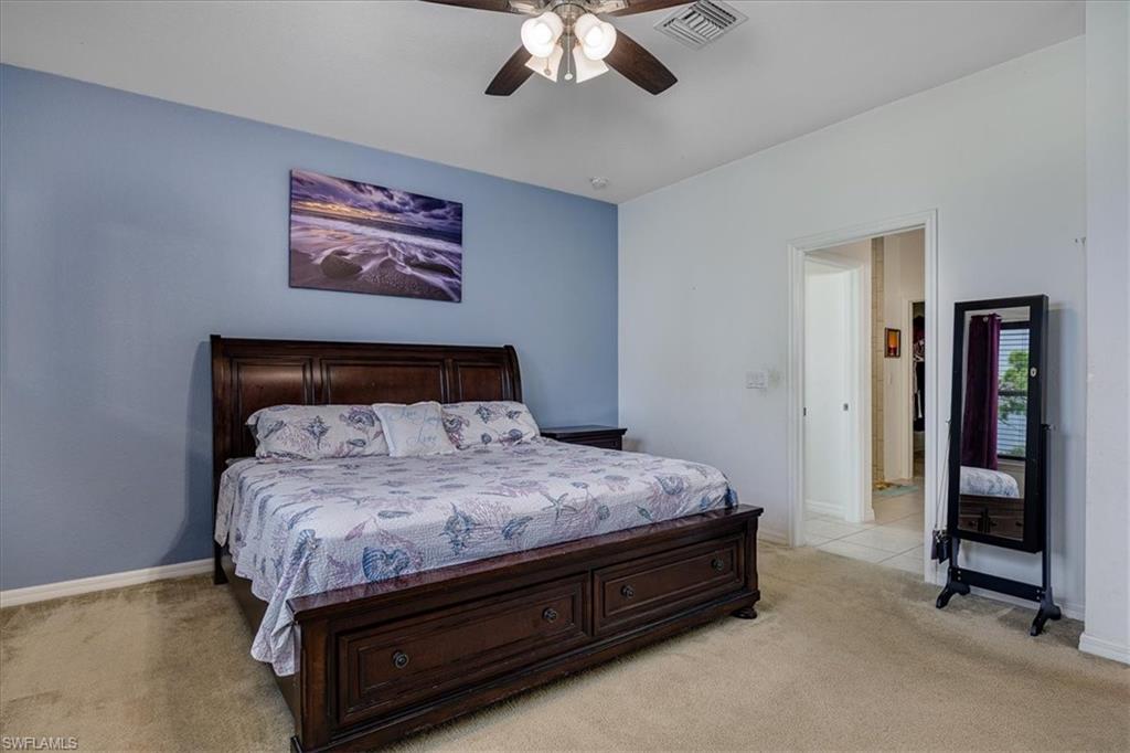 Mast. Bedroom with light carpet and a ceiling fan