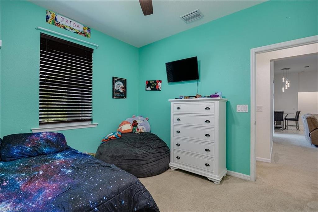 Carpeted bedroom featuring baseboards and a ceiling fan