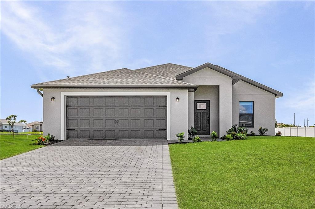 Single story home with an attached garage, decorative driveway, and stucco siding