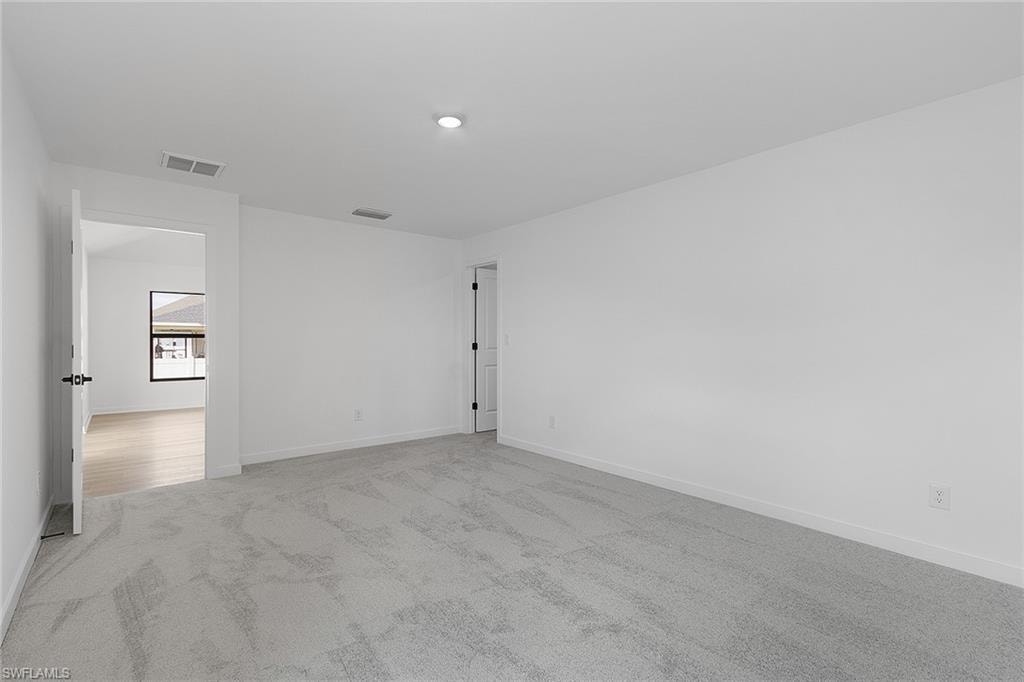 Carpeted spare room with baseboards