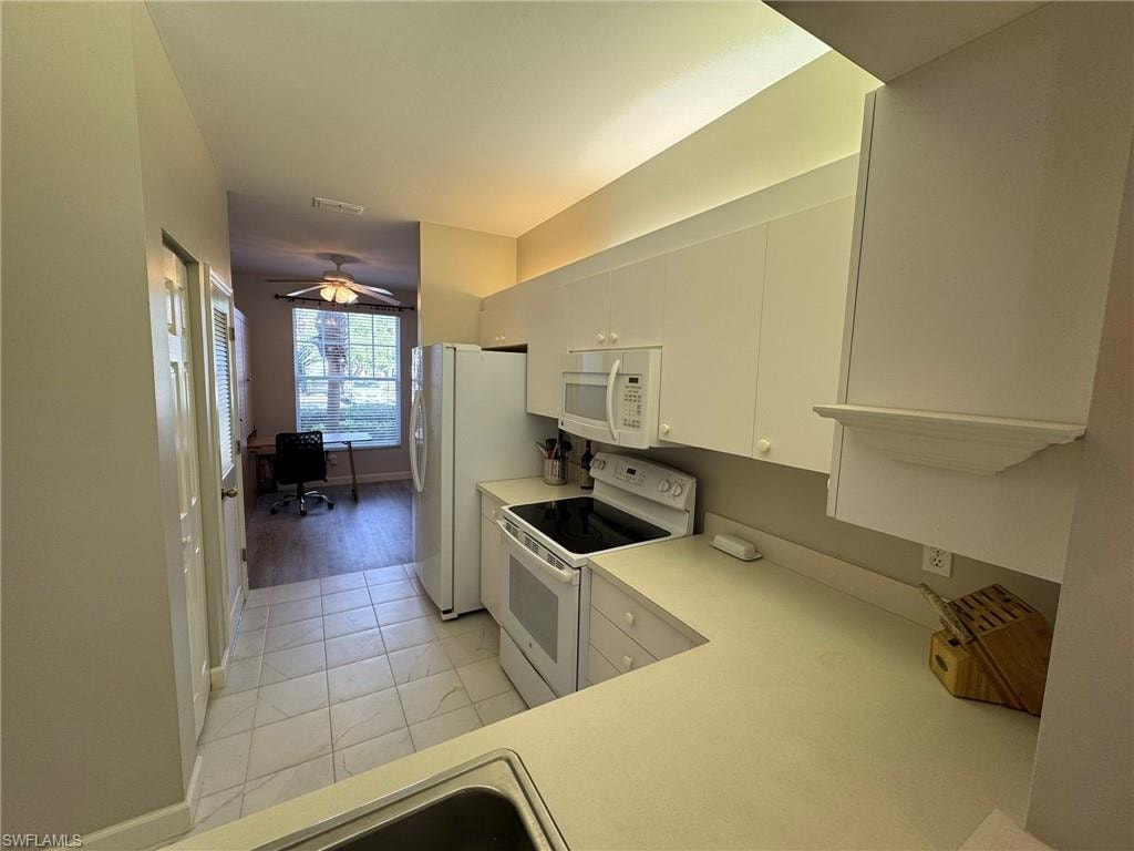 Kitchen featuring white cabinets and white appliances