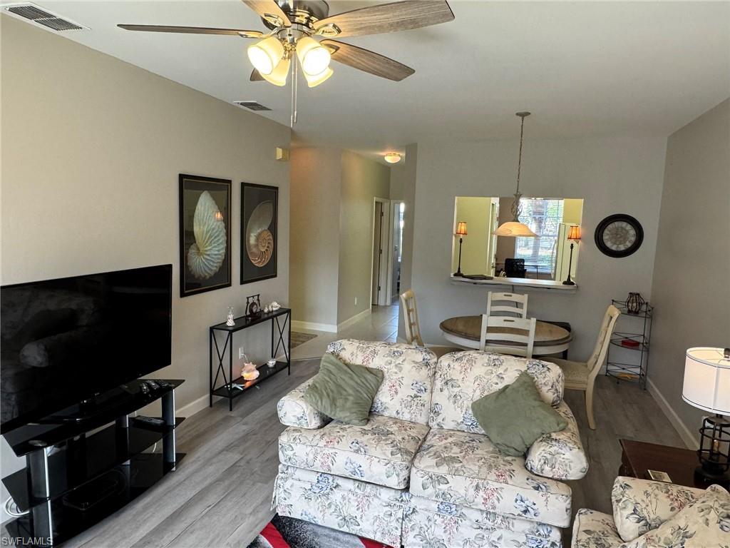 Living room with ceiling fan and light hardwood / wood-style floors