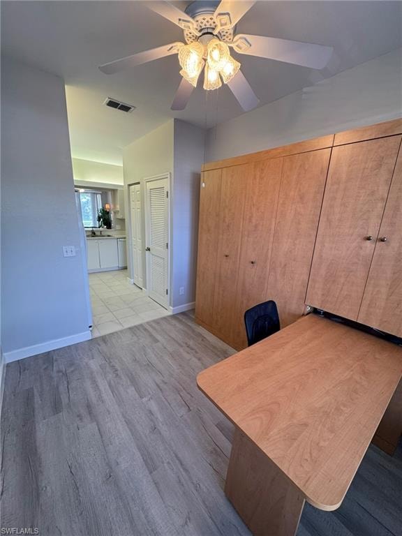 furnished office with ceiling fan, and light wood-type flooring