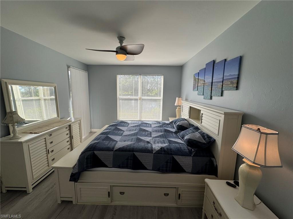 Bedroom featuring ceiling fan, multiple windows, and light hardwood / wood-style flooring