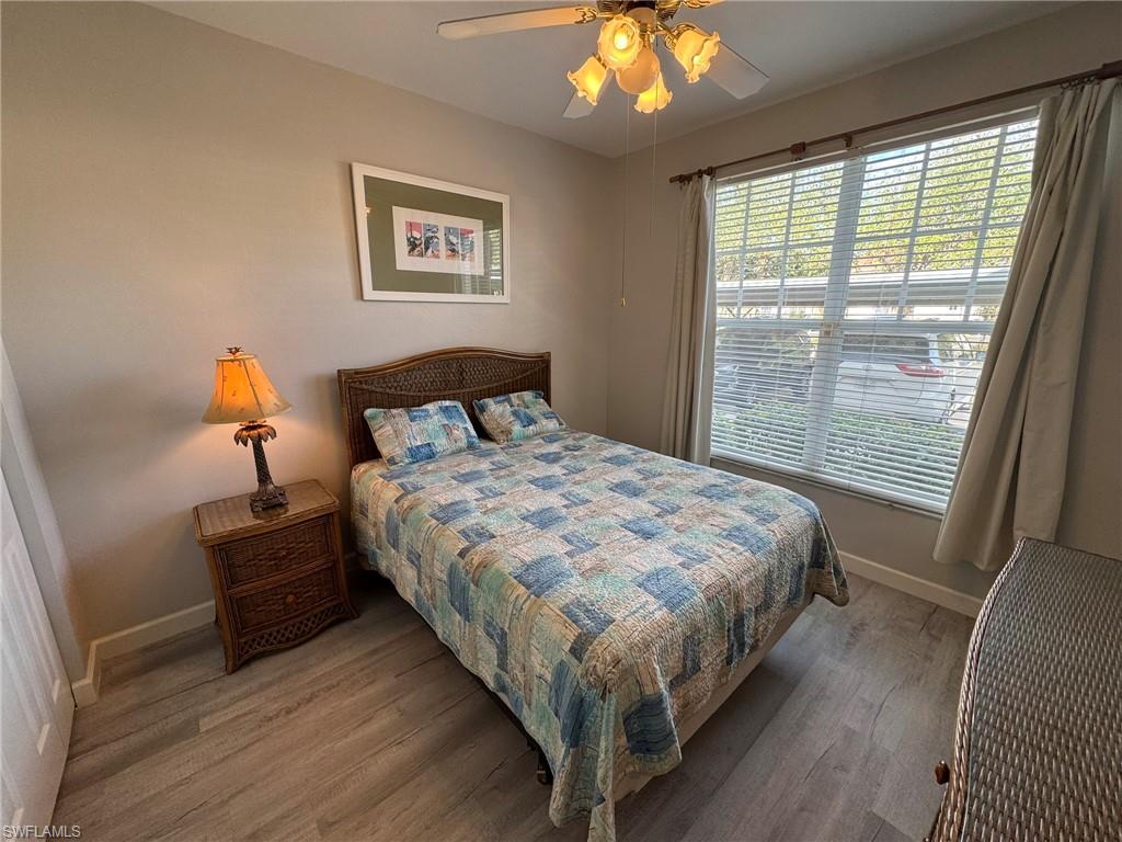 Bedroom with multiple windows, hardwood / wood-style flooring, and ceiling fan