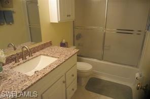 Full bath with combined bath / shower with glass door and vanity
