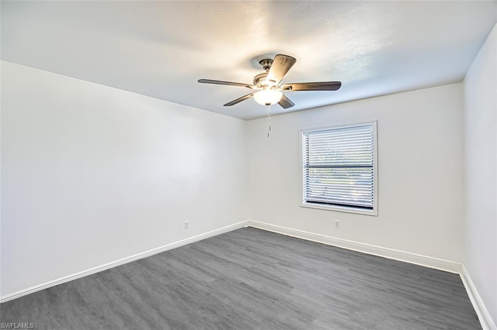 Empty room featuring wood finished floors and a ceiling fan