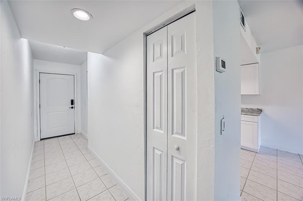 Hall featuring light tile patterned floors and baseboards