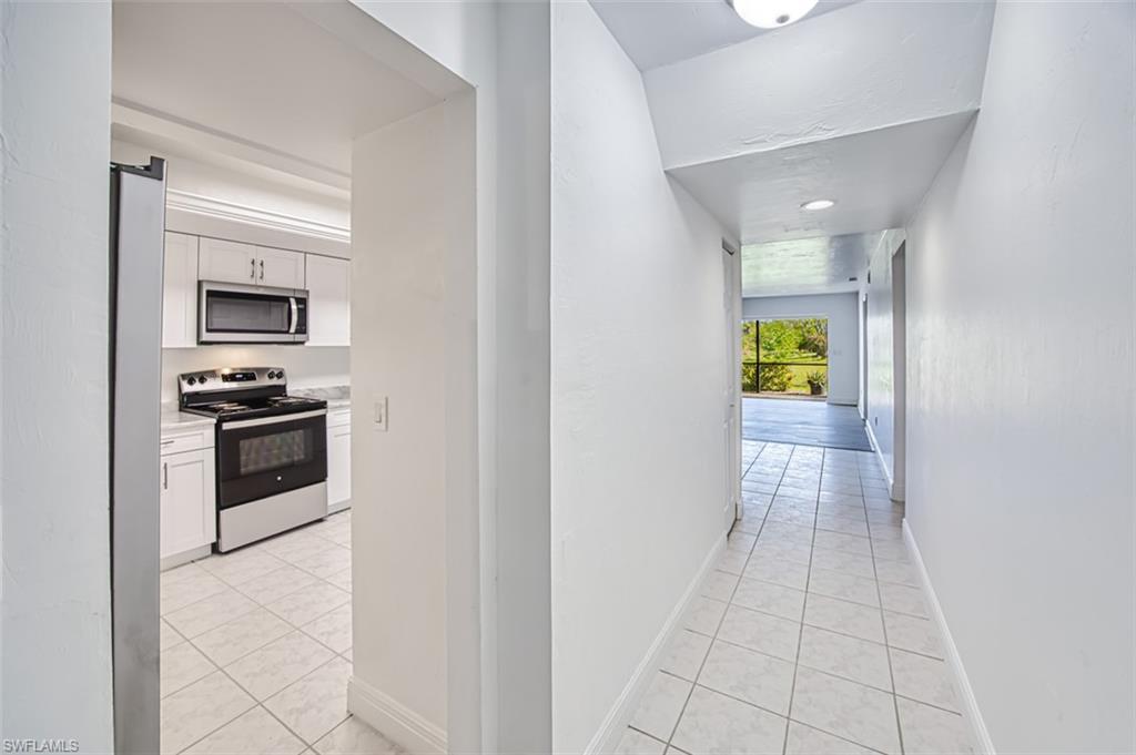 Hallway featuring light tile patterned flooring and baseboards