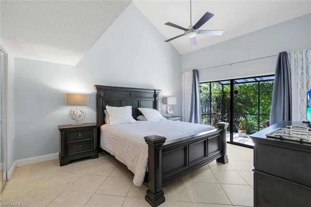 Bedroom with access to exterior, high vaulted ceiling, light tile patterned floors, a ceiling fan, and a textured ceiling
