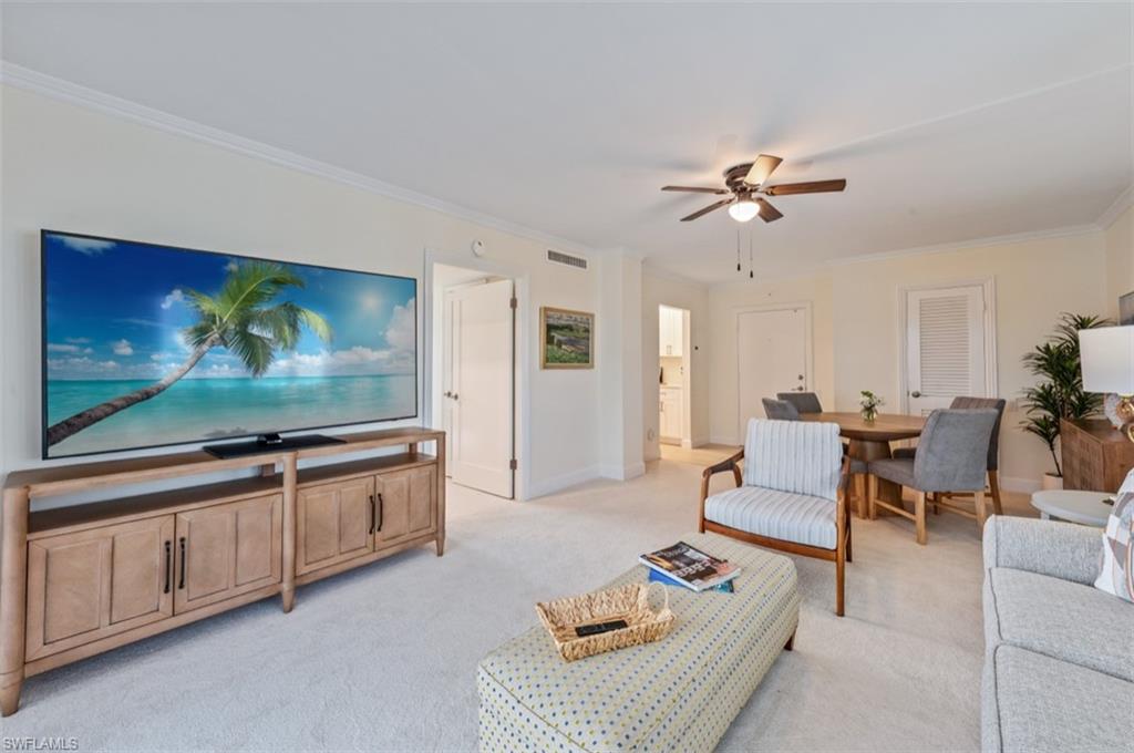 Living area featuring crown molding, light carpet, and ceiling fan