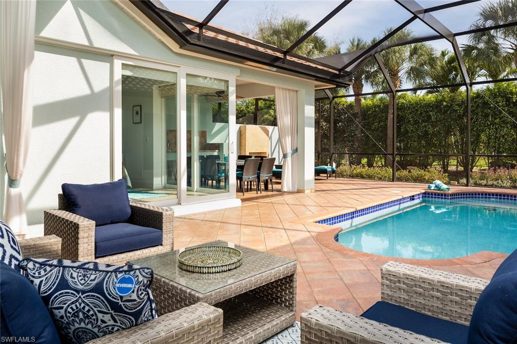 Swimming pool featuring a patio area, a sunroom, and glass enclosure