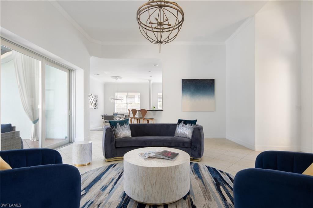 Tiled living area with a chandelier and crown molding
