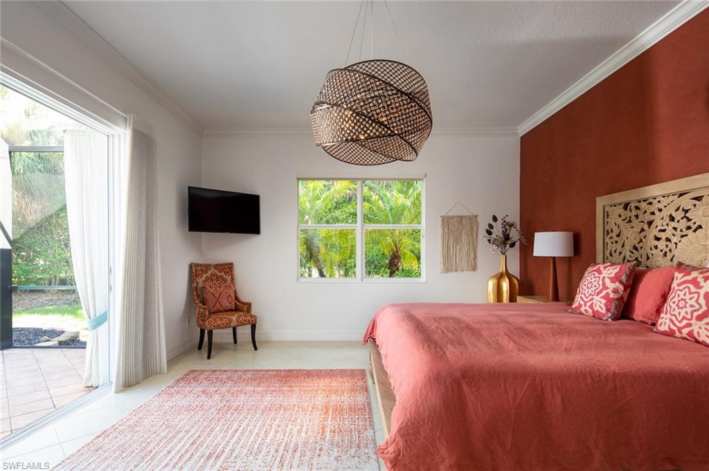 Bedroom featuring crown molding, access to exterior, tile patterned floors, and a chandelier