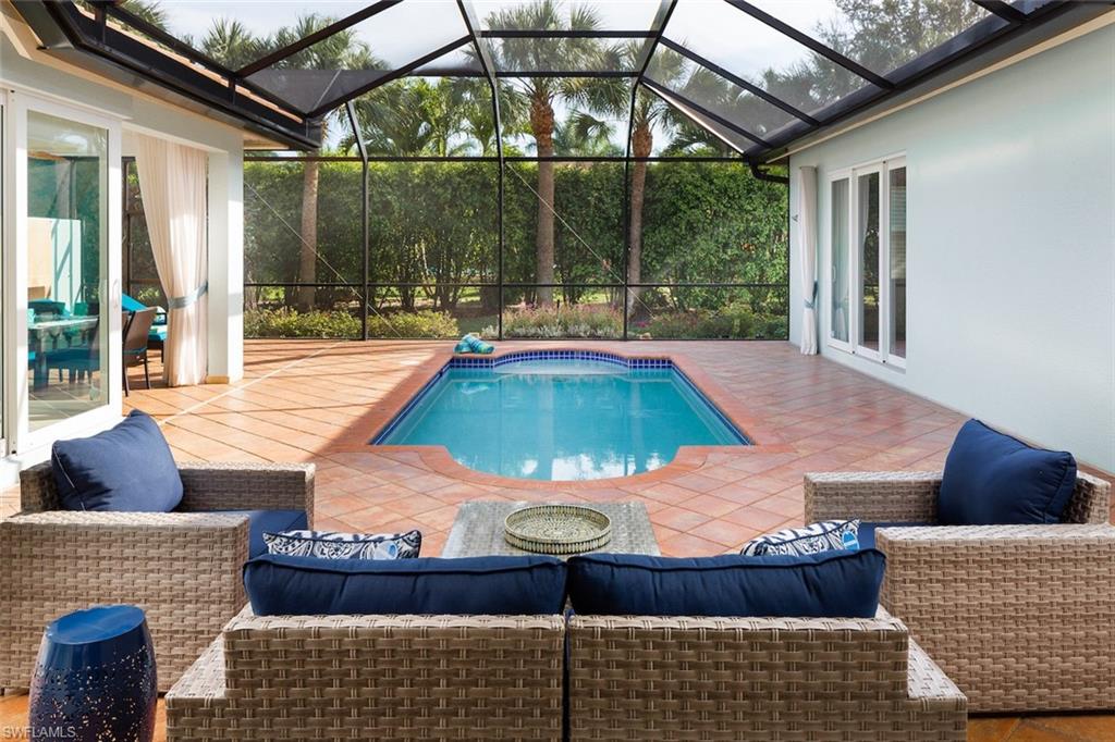 Outdoor pool featuring a patio area, a sunroom, and glass enclosure