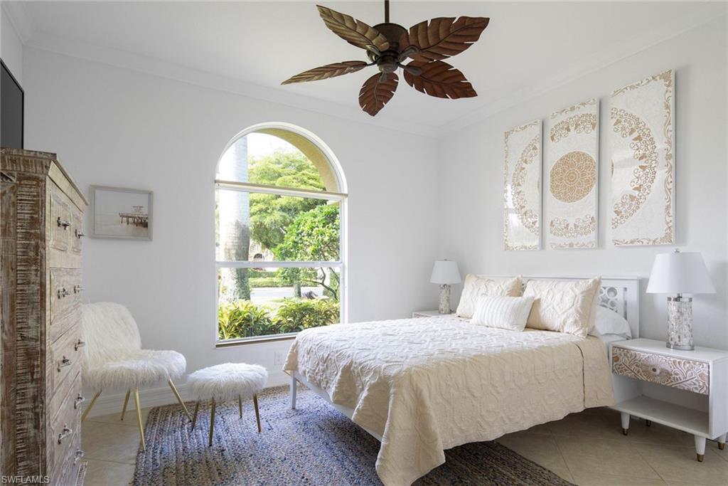 Tiled bedroom with crown molding and a ceiling fan