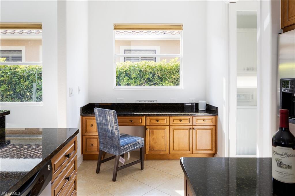 Office with built in desk and light tile patterned flooring