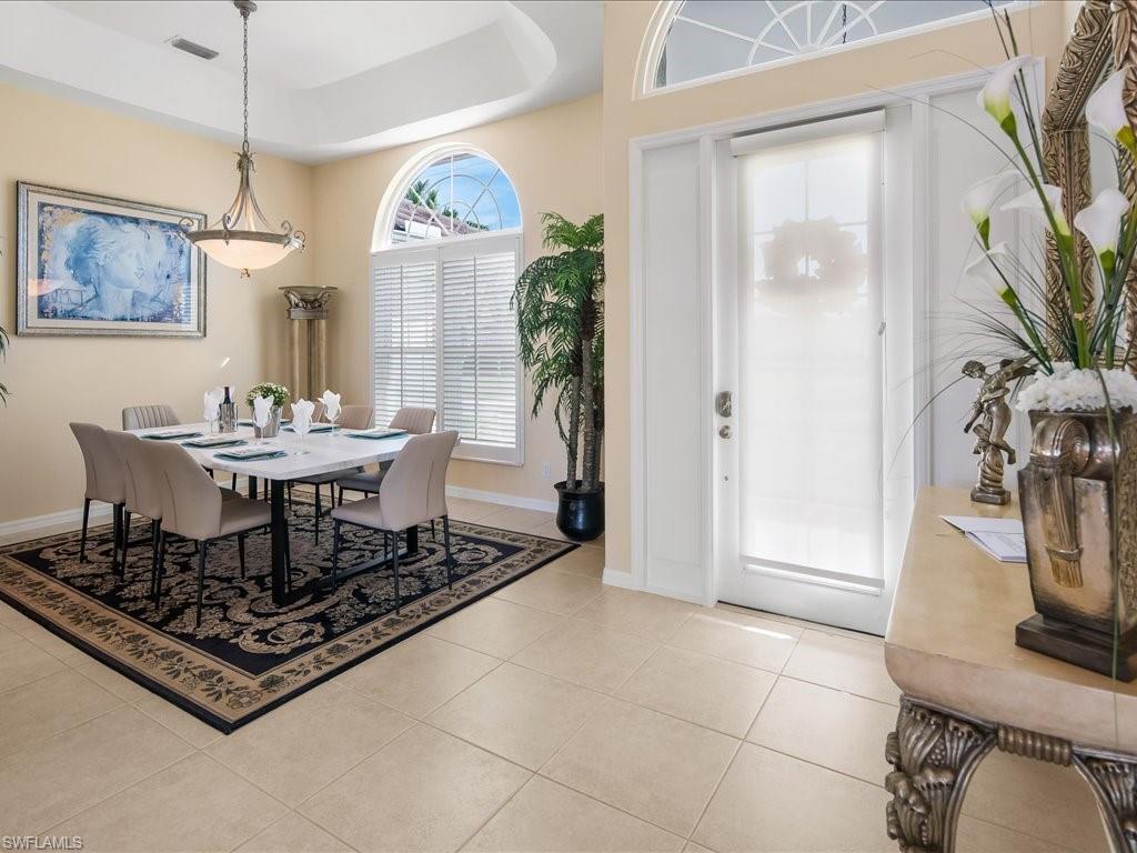 Dining space featuring a raised ceiling and light tile patterned floors