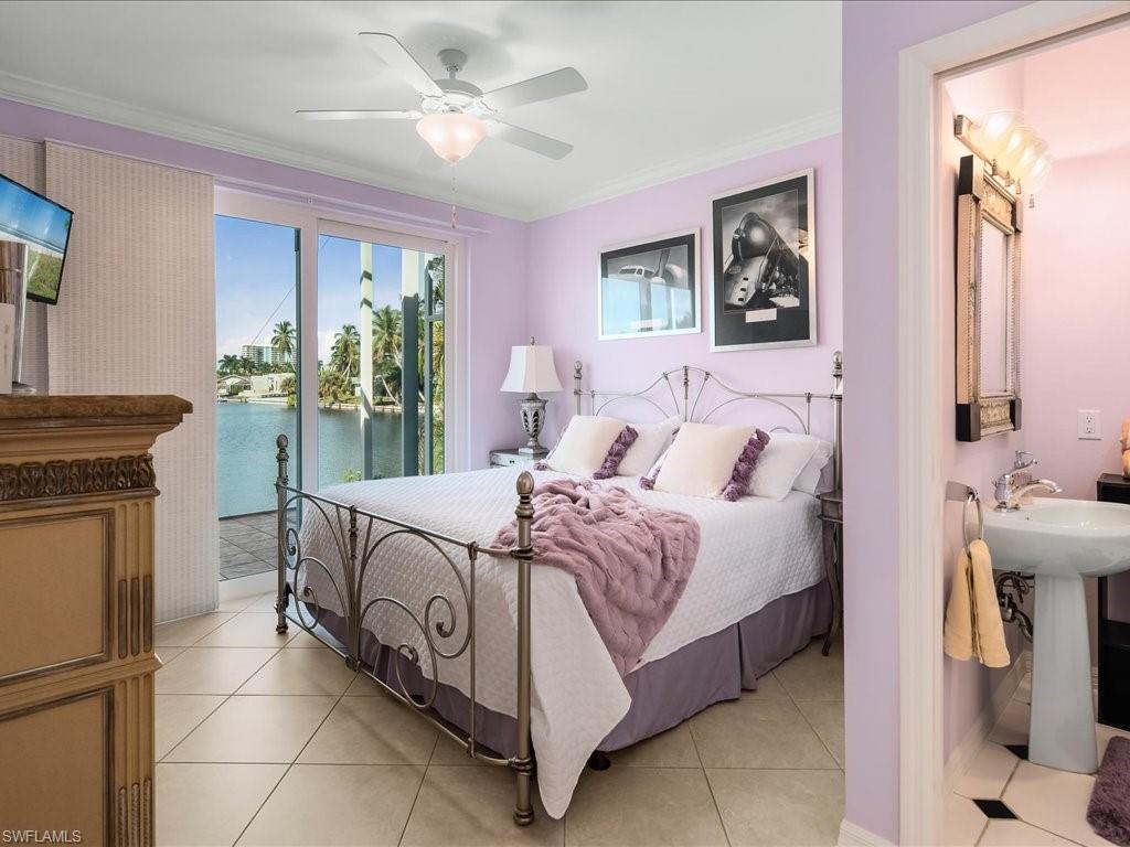 Bedroom with light tile patterned floors, crown molding, a water view, ceiling fan, and access to exterior