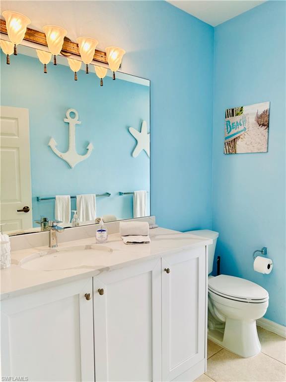 Half bathroom featuring light tile patterned floors and vanity