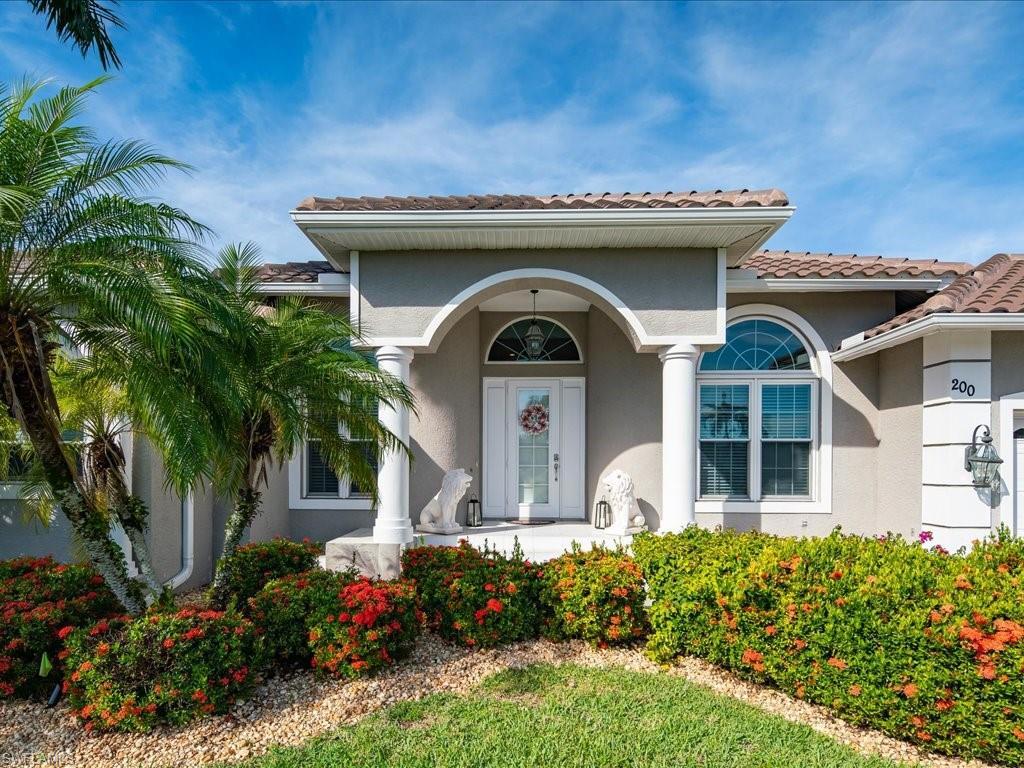 View of exterior entry with a porch, stucco siding, and a tiled roof